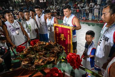 Members of a third-placed team receive their prize: A platter of roast duck