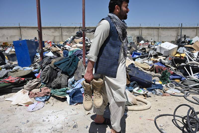 A man holds shoes as he selects valuable items at a recycling workshop near the Bagram Air Base. AFP