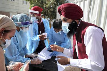 DUBAI, UNITED ARAB EMIRATES , Feb 6 – HEALTH WORKERS WITH THE LIST OF PEOPLE WHO ARE GETING THE FIRST DOSE OF SINOPHARM VACCINATION DURING THE VACCINATION DRIVE AT THE GURU NANAK DARBAR GURUDWARA IN DUBAI. Guru Nanak Darbar Gurudwara has partnered with Tamouh Health Care LLC, to provide on-site Sinopharm Vaccination for all residents of the UAE free of charge on 6th, 7th & 8th February 2021. (Pawan Singh / The National) For News/Online