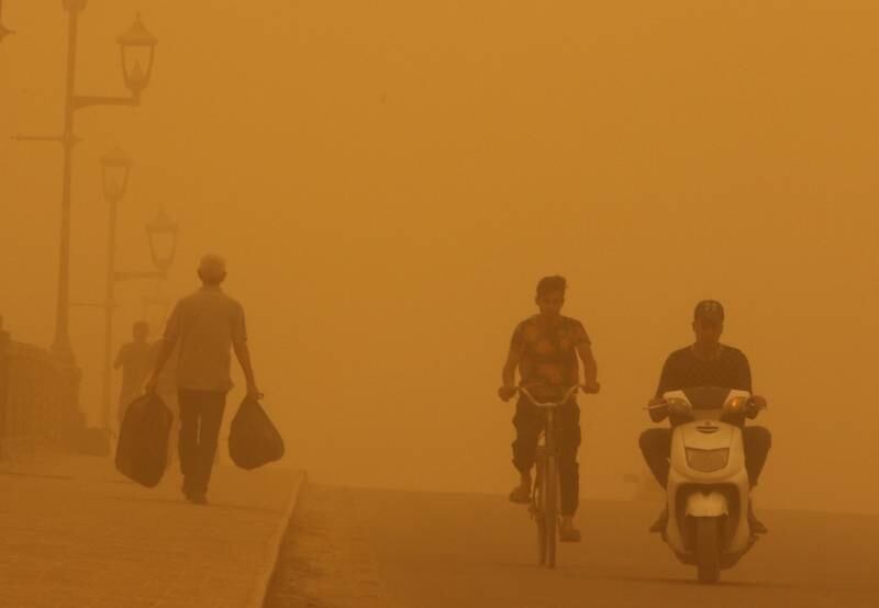 People cross a bridge during a sandstorm in Baghdad. Reuters
