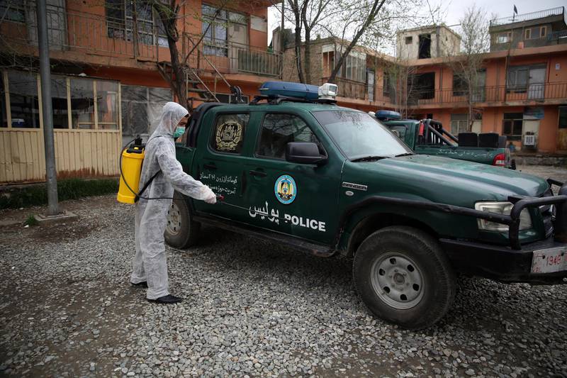 A volunteer in a protective suit sprays disinfectant on a police truck outside a local police station to help curb the spread of coronavirus in Kabul, Afghanistan, on March 23, 2020. AP Photo