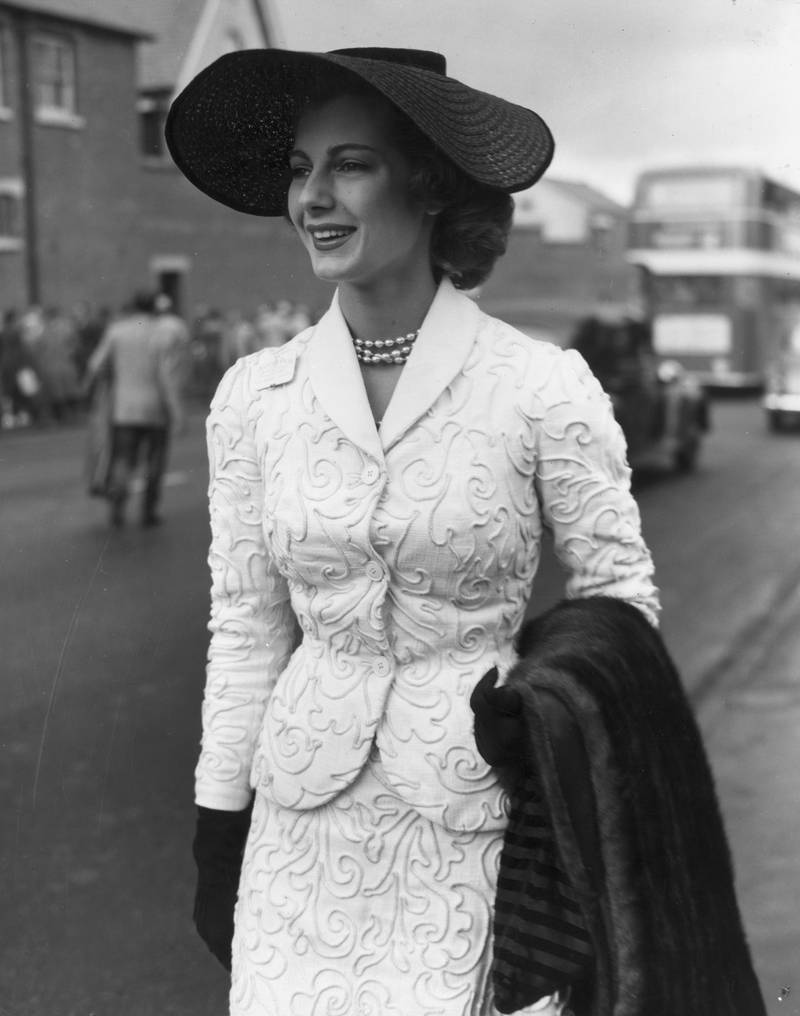 Model Fiona Campbell-Walter, as known as Baroness Thyssen-Bornemisza, wears a black straw hat and a white corded suit in 1953. Getty Images