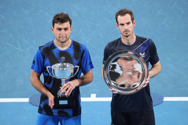 Aslan Karatsev, left, poses with the winner's trophy next to runner-up Andy Murray after winning the Sydney Tennis Classic. AFP