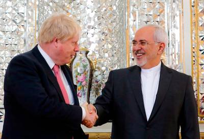 Iran's Foreign Minister Mohammad Javad Zarif (R) shakes hands with his British counterpart Boris Johnson during a meeting in Tehran on December 9, 2017. / AFP PHOTO / ATTA KENARE