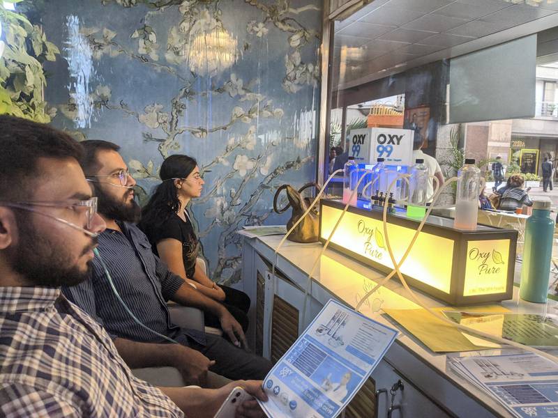 Customers inhaling clean air using a cannula strapped to their nostrils at Oxy Pure, an oxygen bar at Select Citywalk mall in New Delhi on Saturday. Taniya Dutta for The National
