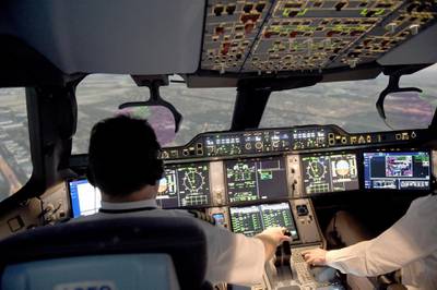 This photograph taken on September 16, 2019, shows Air France pilots inside an Airbus A350 flight simulator at the company training centre near Roissy Charles de Gaulle airport, north-east of the French capital Paris. - "Ready for take off?" "Take off!" The A350 launches onto the runway, takes off, before a "reactor pumping" phenomenon disrupts the well-oiled mechanics: we are in a simulator where Air France pilots put their skills to the test. "The simulator is a central tool in pilot training, at the heart of the training and safety issues," explains Eric Prévot, captain on the Boeing 777 at Air France and spokesman for the company's flight operations. (Photo by ERIC PIERMONT / AFP)