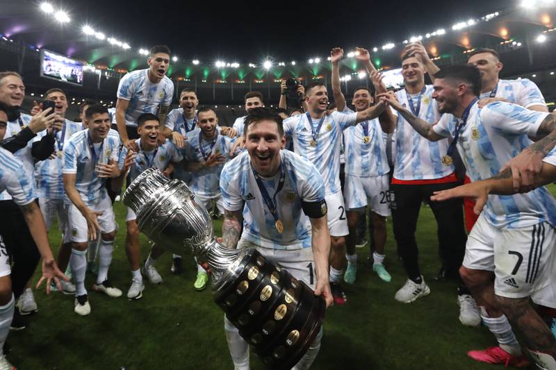 Lionel Messi holds the trophy as he celebrates with the team. AP