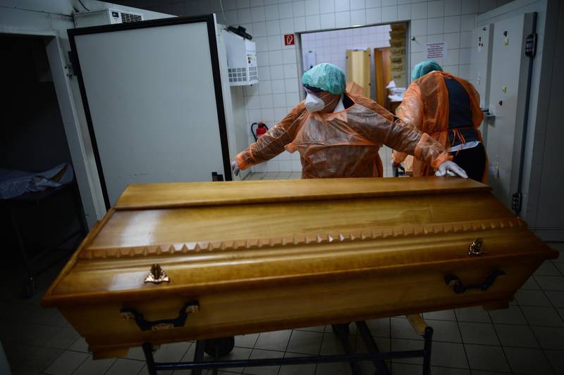ANNABERG-BUCHHOLZ, GERMANY - DECEMBER 07: Workers at a funeral home move coffins with bodies of Covid-19 victims during the second wave of the coronavirus pandemic in the state of Saxony on  December 7, 2020 in Annaberg-Buchholz, Germany. Saxony currently has the highest concentration of high coronavirus infection rates nationwide, with 10 of its 12 counties recording infection rates of well over 200 per 100,000 over seven days. Its three eastern-most counties of Bautzen, Goerlitz and Saxon Switzerland/Eastern Ore Mountains are averaging over 450. Nationwide Germany is struggling to bring down infection rates that have been averaging around 18,000 per day since October, with daily death rates averaging around 380. (Photo by Alexander Koerner/Getty Images)