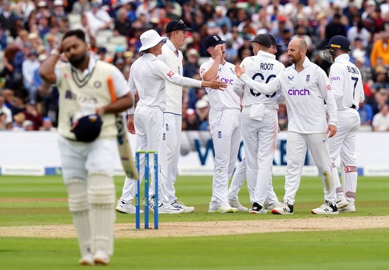 India's Rishabh Pant trudges off as England spinner Jack Leach celebrates taking the wicket with teammates. PA