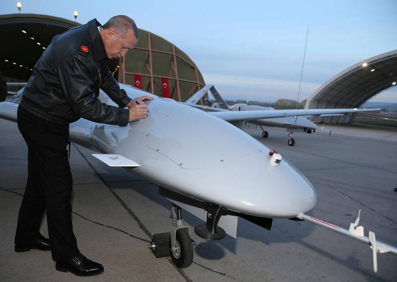 Turkey's President Recep Tayyip Erdogan signs a drone at a military airbase in Batman, Turkey, Saturday, Feb. 3, 2018. The Turkish military says two of its soldiers have been killed in Syria and a third was killed on the Turkish side of the border in an attack by Syrian Kurdish militiamen, saying Saturday's deaths were related to Turkey's operation against the Syrian Kurdish-held enclave of Afrin. (Murat Cetinmuhurdar/Pool Photo via AP)