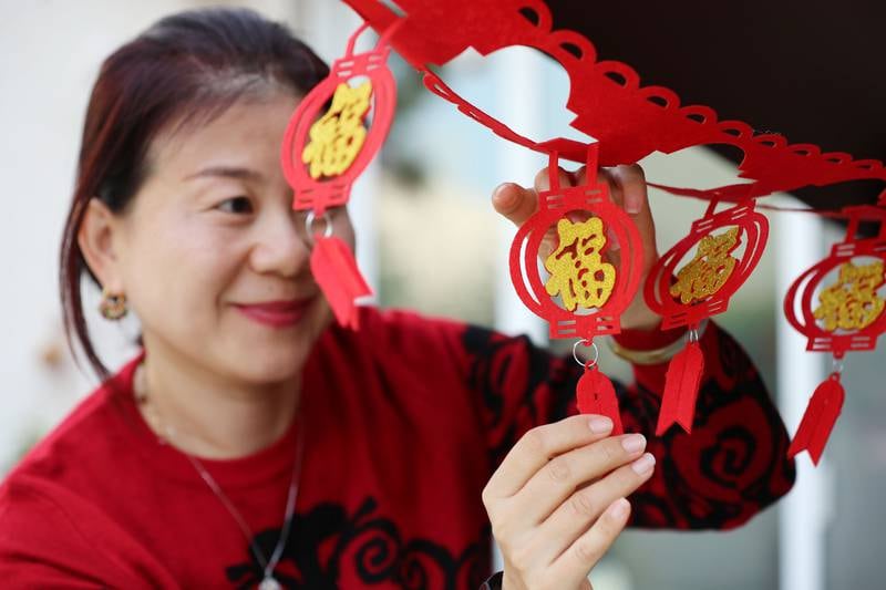 Daisy Chen puts the finishing touches to a colourful new year decoration. Chris Whiteoak / The National