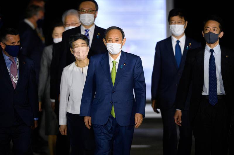 Japan's Prime Minister Yoshihide Suga and his wife Mariko Suga arrive ahead of the G7 meeting, at Cornwall Airport in Newquay, Britain, June 11, 2021. Leon Neal/Pool via REUTERS