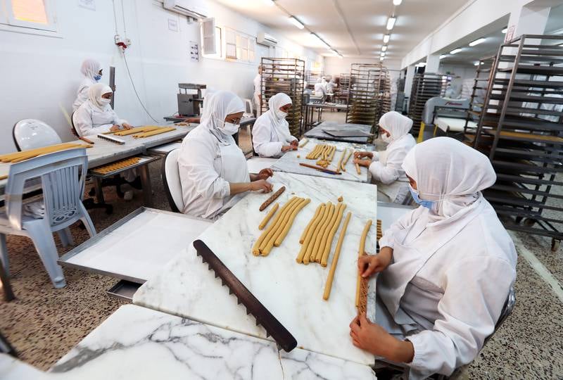 Tunisian women prepare rolled pastries.