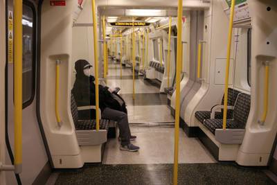 Tube commuters wearing PPE travel during the evening 'rush hour' on the Circle Line, in central London.  AFP