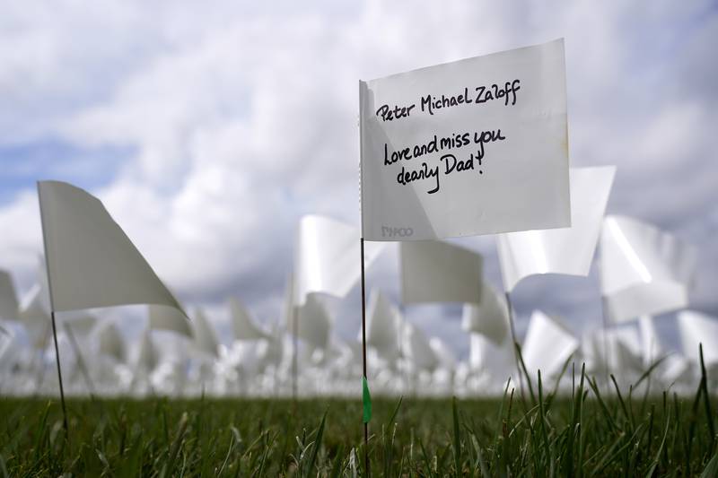 FILE - In this Sept.  21, 2021, file photo, message marks a white flag that is part of artist Suzanne Brennan Firstenberg's "In America: Remember," a temporary art installation to commemorate Americans who have died of COVID-19, on the National Mall in Washington.  (AP Photo / Patrick Semansky, File)