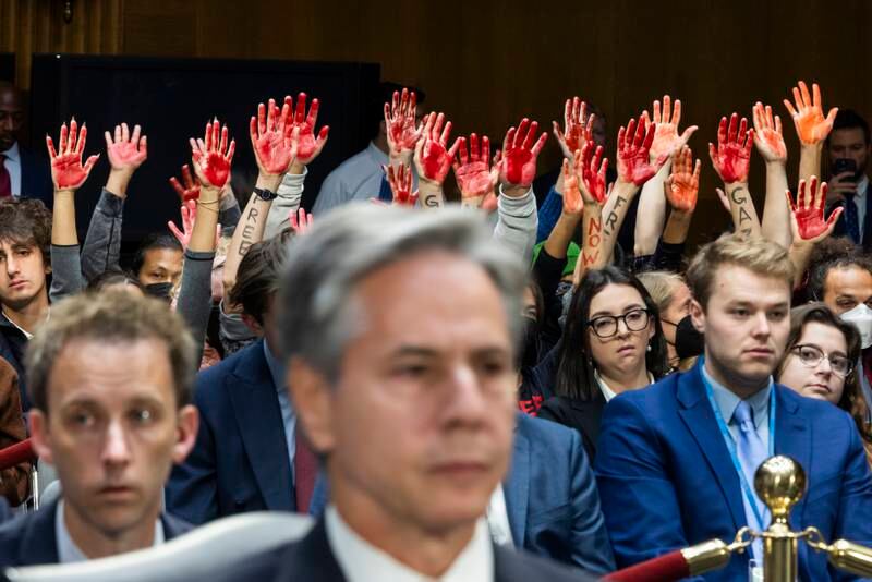 Protesters raise their arms and call for a ceasefire in Gaza in the presences of US Secretary of State Antony Blinken, in the Dirksen Senate Office Building in Washington, on October 31.  EPA