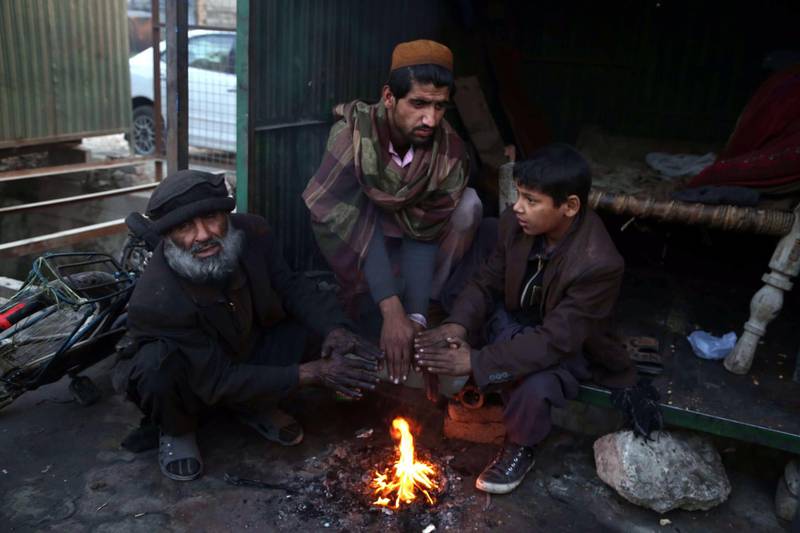 epa07255212 Afghan men gather around a fire to beat the cold in Jalalabad, Afghanistan, 31 December 2018. Due to the lack of electricity, the majority of people in Afghanistan use coal and wood as the only energy supply for warming their houses and cooking during the winter season.  EPA/GHULAMULLAH HABIBI