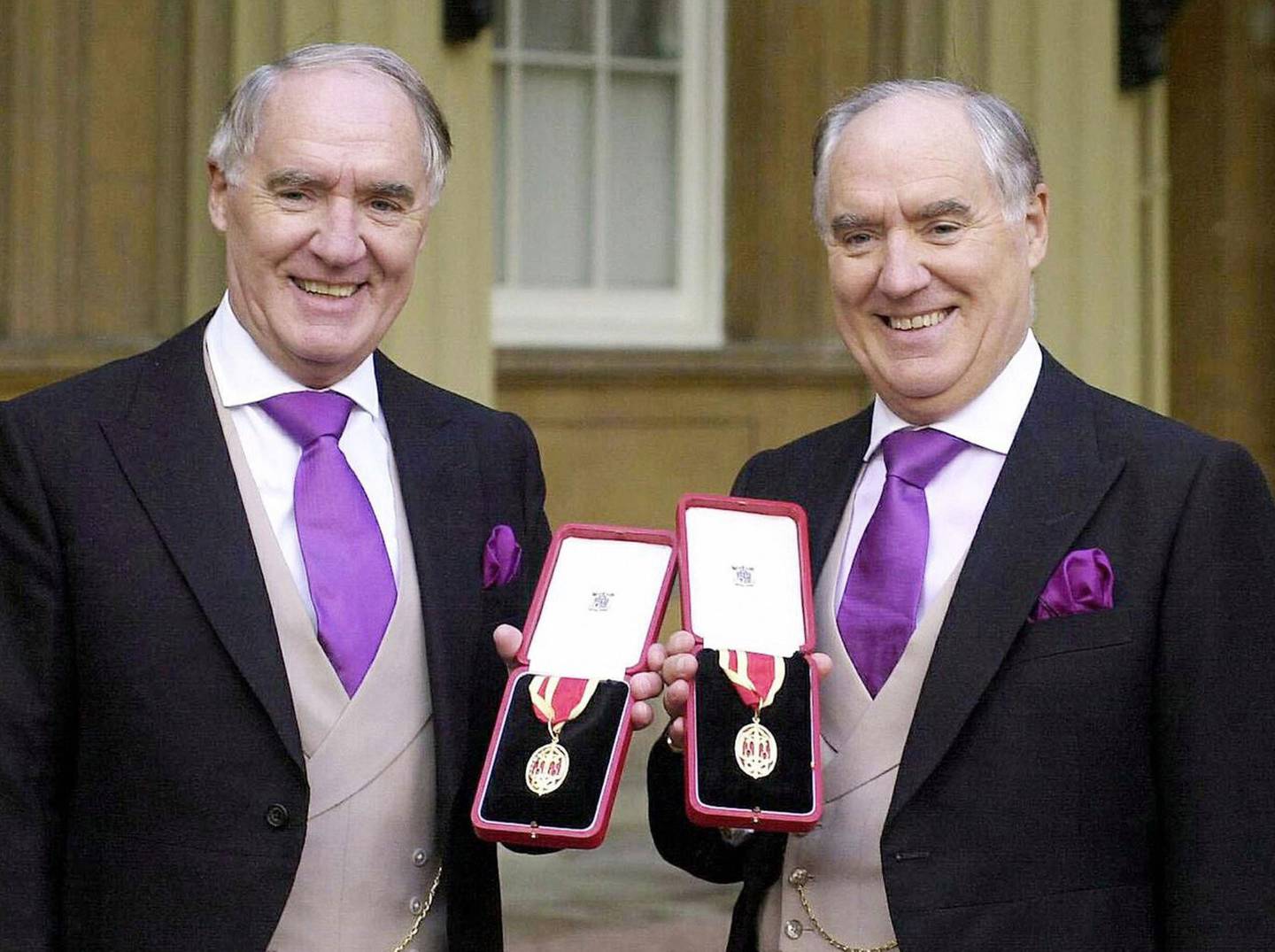 (FILES) This 31 October 2000 file photo shows Sir David Barclay (L) and his twin brother Sir Frederick posing after receiving their knighthoods from the Queen at Buckingham Palace.  In a 100-page opinion issued 26 February, 2004, which included scathing criticism of tycoon Conrad Black, Vice Chancellor Leo Strine of the Delaware Chancery Court said he was going to issue an injunction against the sale of Hollinger International to the Barclay brothers.       AFP PHOTO/WPA ROTA POOL/FILES/MICHAEL  STEPHENS (Photo by MICHAEL STEPHENS / AFP FILES / AFP)