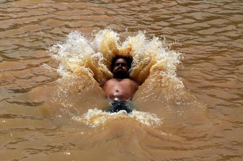 A man dives into the water to beat the heat in gauribidanur village, doddaballapur district, around 85km from Bangalore.  Jagadeesh NV / EPA