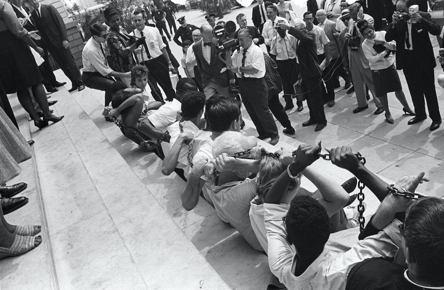 Black and white people chain themselves and sit in front of the New York City Hall, on August 23, 1963, during a protest against segregation in some of states in America. 1963 is noted for racial unrest and civil rights demonstrations from California to New York, culminating in the March on Washington on August 1963 with Martin Luther King, Jr. (Photo by - / AFP)