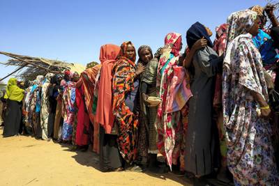 Displaced Sudanese women wait for the arrival of the World Food Programme (WFP) aid in the Otash internally displaced people's camp on the outskirts of Nyala town, the capital of South Darfur, on February 1, 2021. (Photo by ASHRAF SHAZLY / AFP)