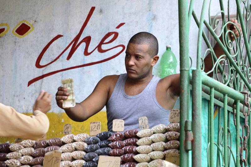 A man sells beans inside a state-run market in Havana. Many Cubans expressed hope the restoration of diplomatic ties between Cuba and the US will mean greater access to jobs and the comforts taken for granted elsewhere. Desmond Boylan / AP Photo