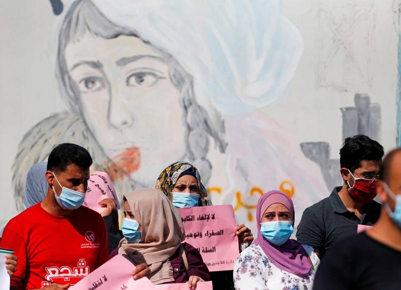 Palestinians wearing a protective masks amid the COVID-19 pandemic attend a rally to protest the reduction of the food basket provided by the United Nations Relief and Works Agency for Palestine Refugees in the Near East (UNRWA) in Gaza City.   AFP