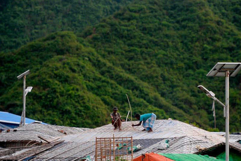 Men renovate a roof of their makeshift house at a camp in Teknaf. AFP