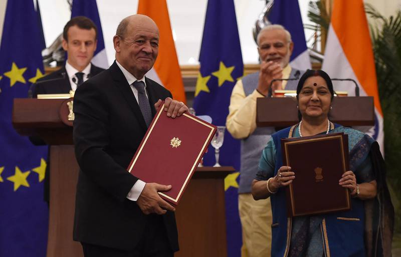 Indian Prime Minister Narendra Modi (R back) and French President Emmanuel Macron (L back) watch as Indian Foreign Affairs Minister Sushma Swaraj (R front) and French Foreign Minister Jean-Yves Le Drian exchange signed bilateral agreements in New Delhi on March 10, 2018.
French President Emmanuel Macron on March 10 said he wanted his country to be India's best partner in Europe as he started a three-day trip to the country aimed at ratcheting up security and energy ties. Macron, who was welcomed by Indian Prime Minister Narendra Modi with his traditional bear hug on his arrival, also said "collective security" will be on top of the agenda during talks later March 10.
 / AFP PHOTO / MONEY SHARMA