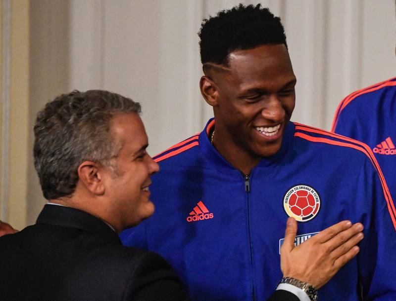 Colombia's President Ivan Duque talks to Colombia defender Yerry Mina. AFP