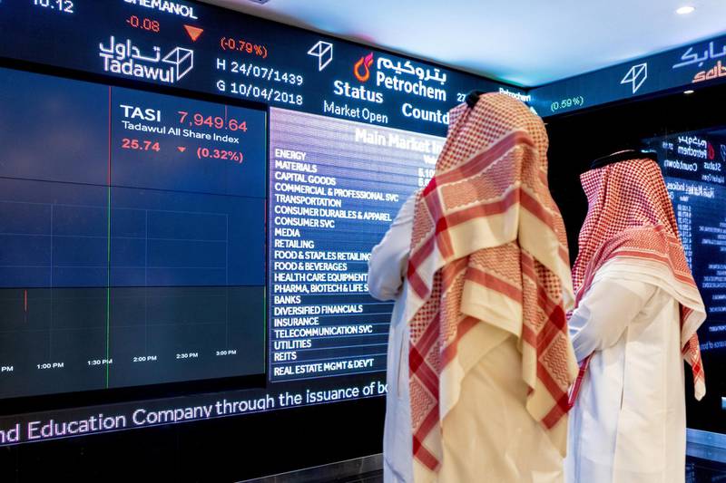Visitors look at stock price information displayed on a digital screen inside the Saudi Stock Exchange, also known as the Tadawul, in Riyadh, Saudi Arabia, on Tuesday, April 10, 2018. Foreign investors bought more Saudi stocks in March than ever before in anticipation of the kingdom���s upgrade to emerging-market status. Photographer: Abdulrahman Abdullah/Bloomberg