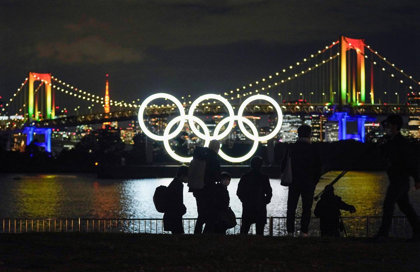 epa08854256 An Olympic rings monument is illuminated as photographers leave after taking photos of the rings lit at the waterfront of Odaiba Marine Park, in Tokyo, Japan, 01 December 2020. The Olympic rings monument has been reinstalled to its original location after maintenance work. The Tokyo 2020 Olympic Games have been rescheduled to open 23 July 2021 and run through 08 August 2021, due to the coronavirus pandemic.  EPA/KIMIMASA MAYAMA