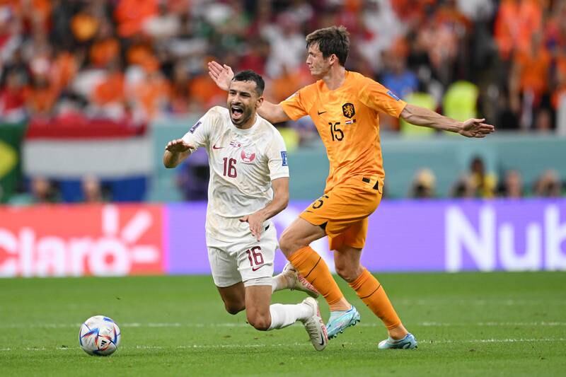 Boualem Khoukhi of Qatar is challenged by Marten de Roon of the Netherlands. Getty 