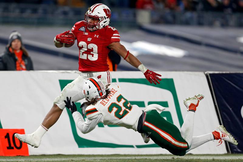 Wisconsin running back Jonathan Taylor (23) is tackled by Miami defensive back Sheldrick Redwine (22) during the second half of the Pinstripe Bowl NCAA college football game. Wisconsin defeated Miami 35-3. AP Photo