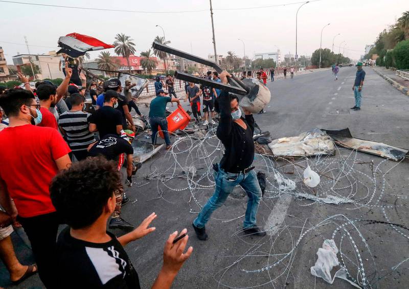 (FILES) In this file photo taken on September 2, 2018, Iraqi protesters gather trash cans and scrap with barbed wire as they erect a make-shift barricade during clashes with security forces following a demonstration against corruption and lack of basic services outside the local government headquarters in the southern city of Basra. With a freshman at the helm, Iraq's electricity ministry is planning a long-awaited overhaul of the broken sector to both meet US pressure to halt Iranian power imports and head off summertime protests over chronic cuts. Baghdad hopes it will generate enough megawatts to feed demand by summer, when cuts can leave millions powerless for up to 20 hours per day. / AFP / Haidar MOHAMMED ALI
