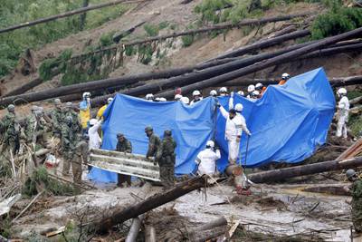 Rescuers at the site of a landslide in Mimata, southern Japan. By Tuesday, two people were known to have died in the storm. AP