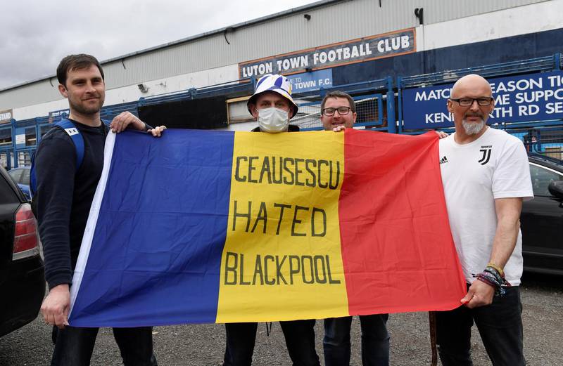 Fams with a Romanian flag outside Luton's ground. Championship matchs have also been suspended. Reuters