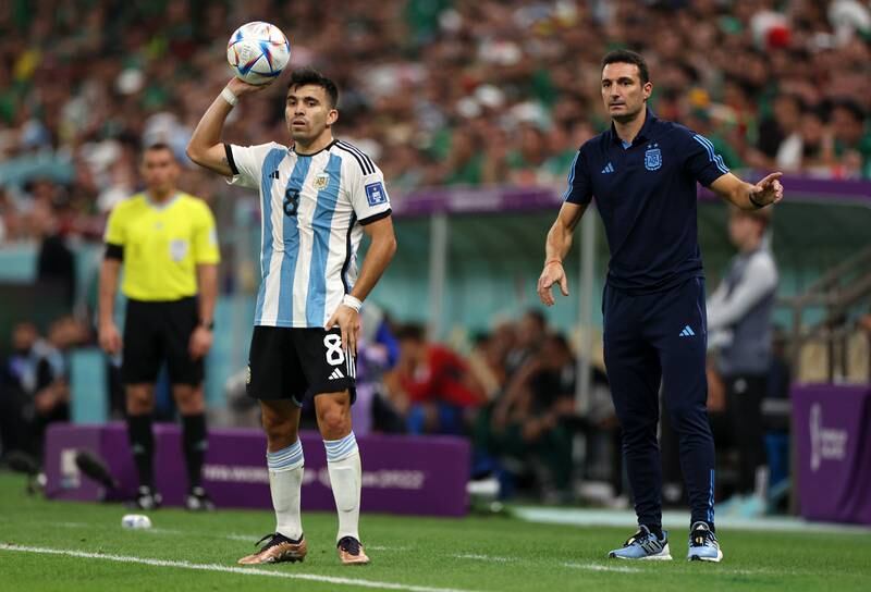 Marcos Acuna of Argentina prepares for a throw in while coach Lionel Scaloni stands on the touchline. Getty