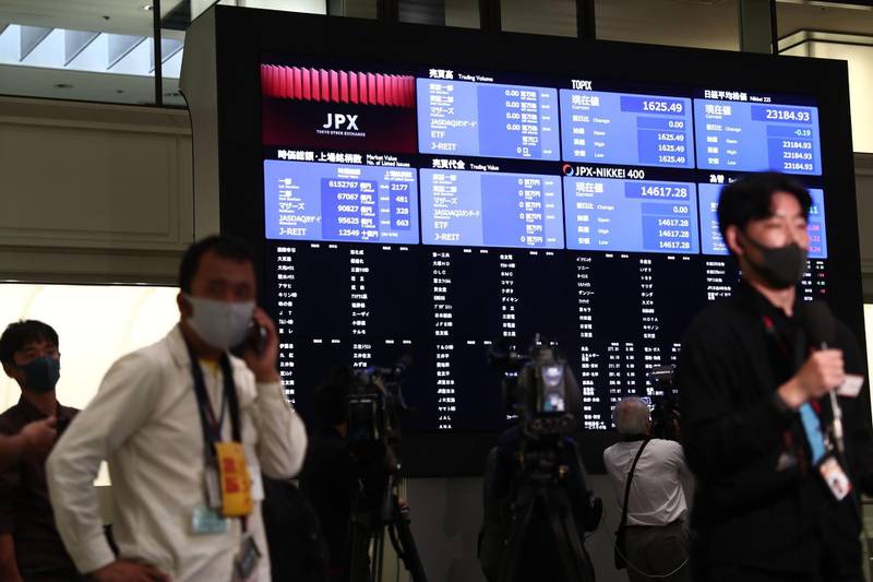 Journalists gather next to an information board inside the Tokyo Stock Exchange where trading was halted due to a glitch on the market in Tokyo on October 1, 2020. / AFP / Behrouz MEHRI

