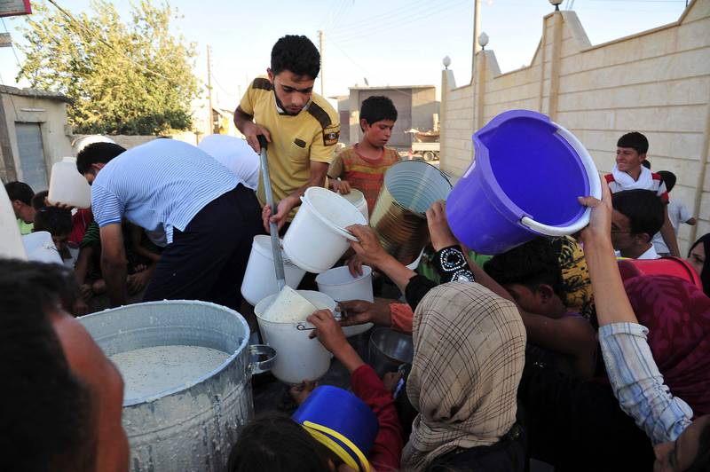 Civilians receive free food for their first iftar, or breaking fast, during the Muslim fasting month of Ramadan in Raqqa province, eastern Syria July 10, 2013. REUTERS/Nour Fourat  (SYRIA - Tags: RELIGION FOOD SOCIETY POVERTY) *** Local Caption ***  SYR47_SYRIA-CRISIS-_0710_11.JPG