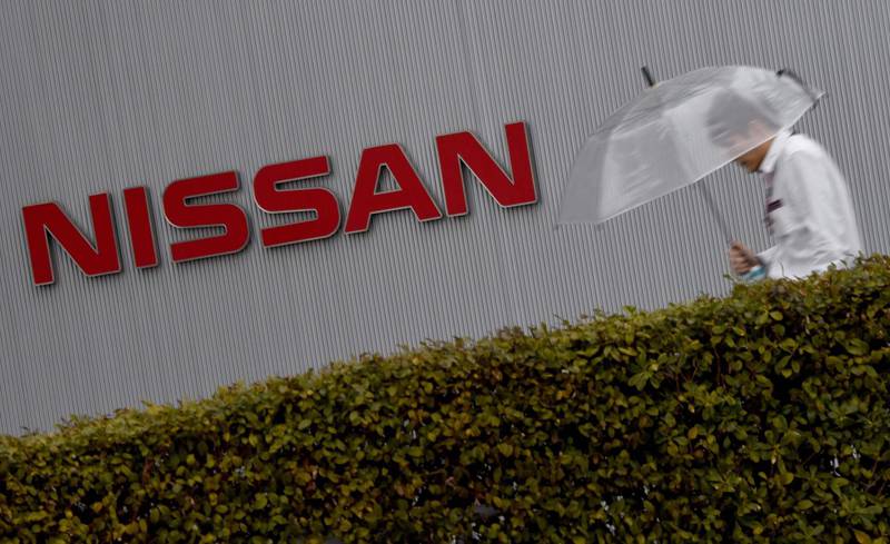 (FILES) This file photo taken on February 9, 2017 shows a man walking past the logo of Japan's auto giant Nissan Motor at the company's headquarters in Yokohama, in suburban Tokyo.
Japanese car giant Nissan on February 8, 2018 slashed its forecast for full-year operating profit after admitting that a damaging inspection scandal last year had "adversely impacted" the firm's performance. / AFP PHOTO / TORU YAMANAKA