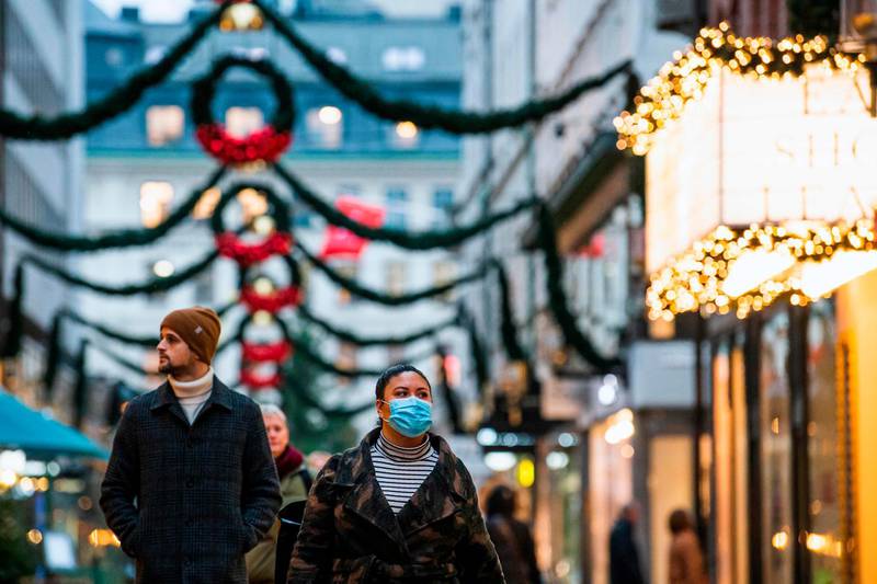 People walk past shops and Christmas decorations in Stockholm, Sweden. AFP
