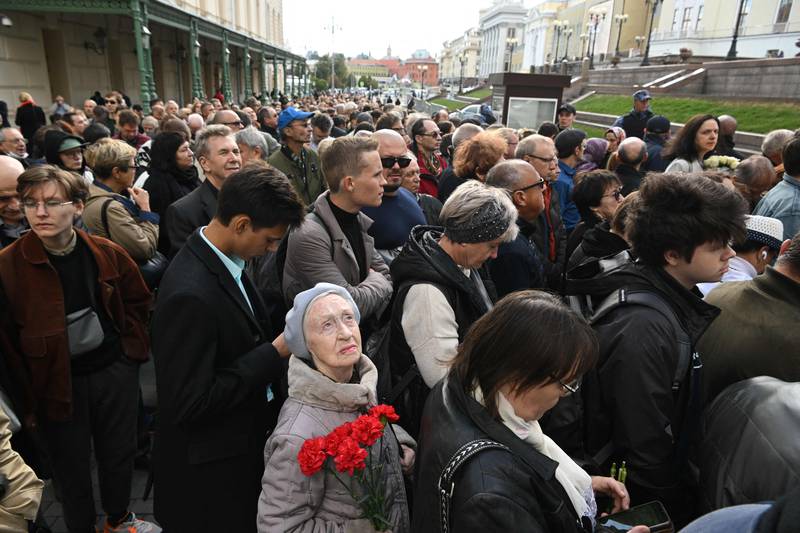 A woman holds flowers as she stands in line to file past the Nobel Peace Prize winner's coffin. AFP