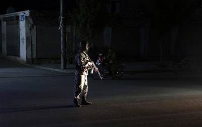 An Afghan police man stand guard outside the wedding hall after an explosion in Kabul, Afghanistan.  AP