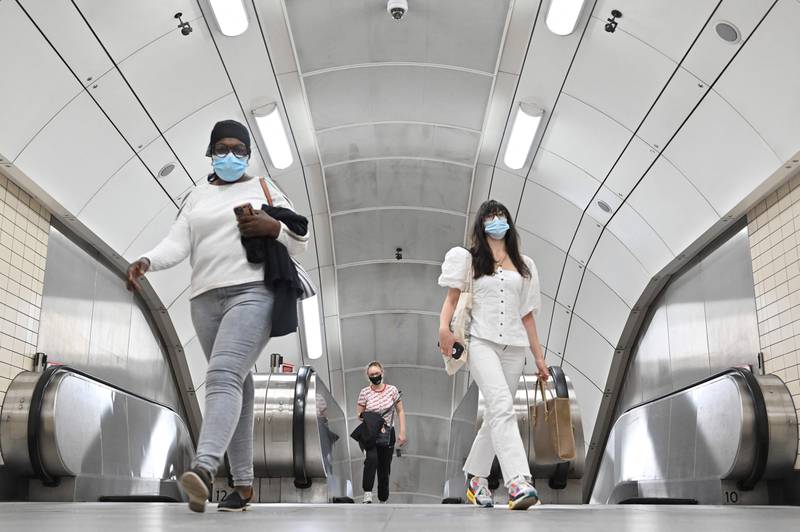 Mask-wearing passengers emerge from the London Underground.