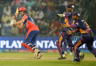 Delhi Daredevils batsman Pat Cummins, left, plays a shot as Rising Pune Supergiants wicketkeeper MS Dhoni, centre, looks on during their 2017 Indian Premier League match at The Feroz Shah Kotla Cricket Stadium in New Delhi on May 12, 2017. Sajjad Hussain / AFP