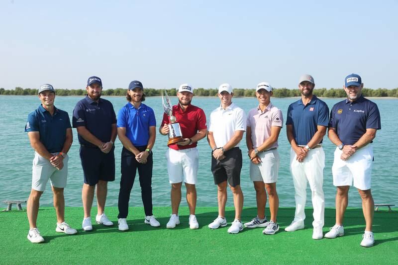 From left, Viktor Hovland, Shane Lowry, Tommy Fleetwood, Tyrrell Hatton, Rory McIlroy, Collin Morikawa, Adam Scott, and Lee Westwood pose with the tournament trophy ahead of the Abu Dhabi HSBC Championship at Yas Links Golf Course. Getty