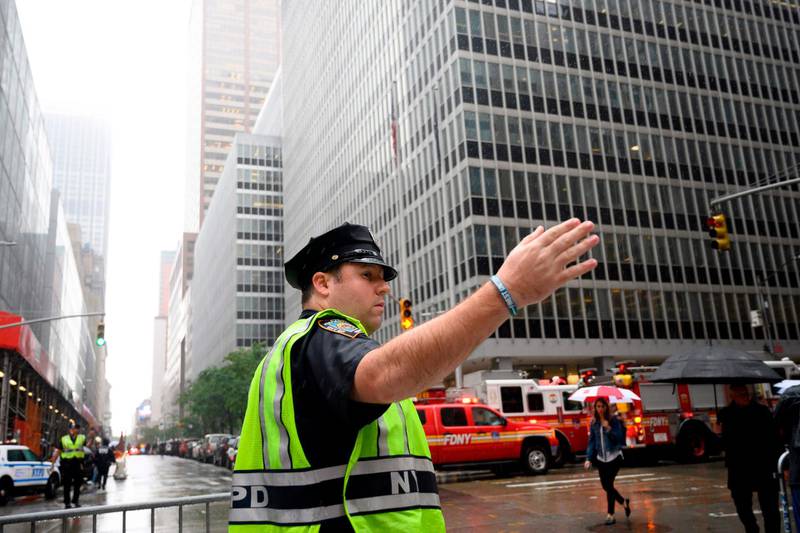 A policeman gestures near fire trucks. AFP