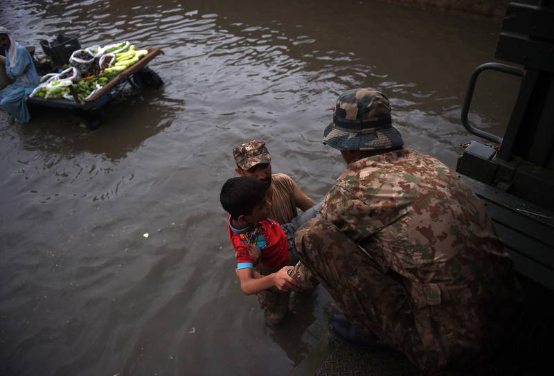 Soldiers rescue a child from a flooded area after heavy monsoon rains in Pakistan's port city of Karachi.  AFP