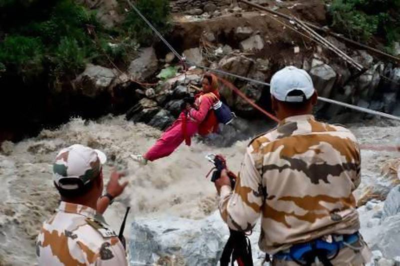 A stranded Indian pilgrim is transported across a river using a rope rescue system by Indo-Tibetan border police in Govind Ghat during the recent floods.